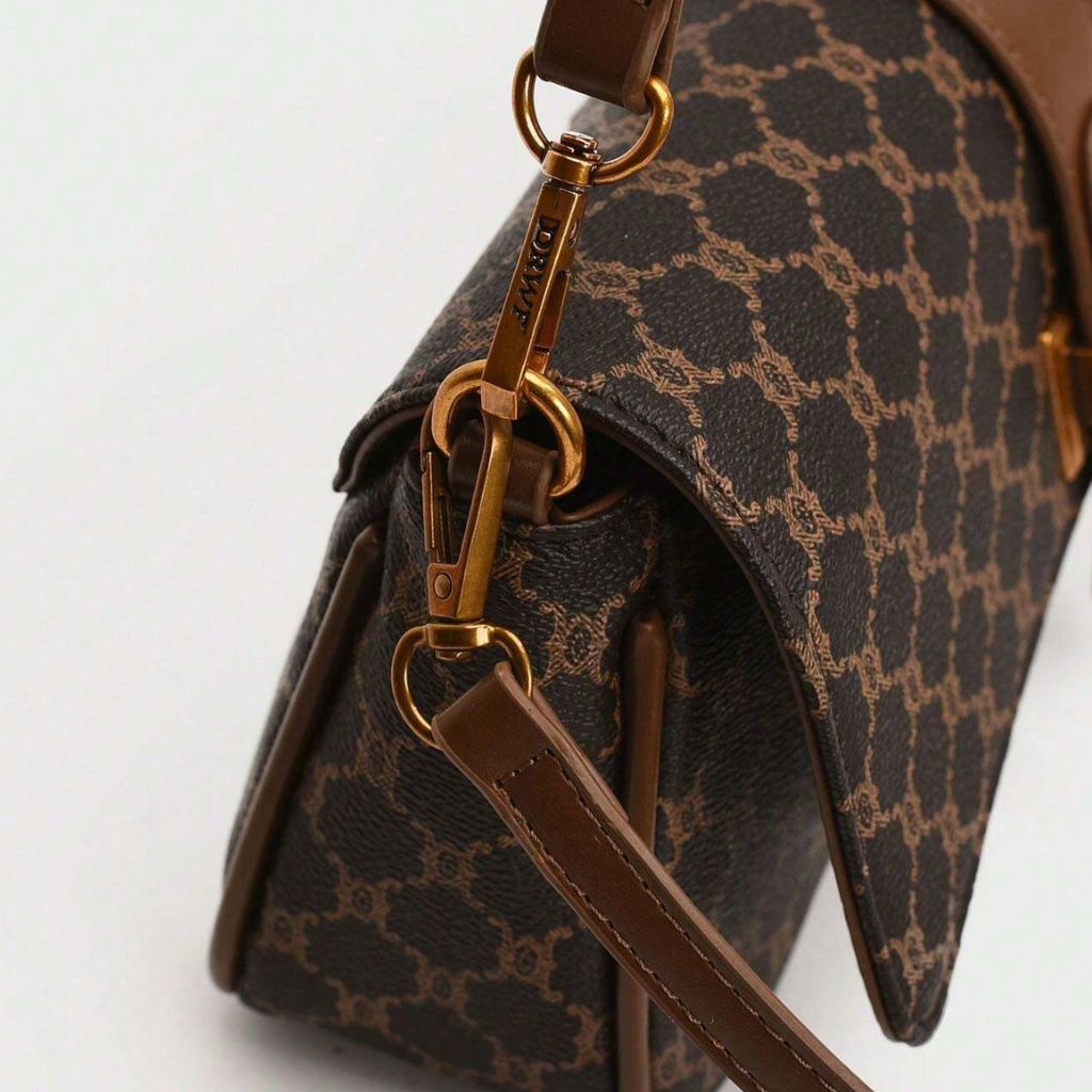 Bolsa baguete Yeda Mayzê. Design retrô em couro ecológico, estampa clássica e alça transversal. O acessório perfeito para looks modernos e sofisticados.