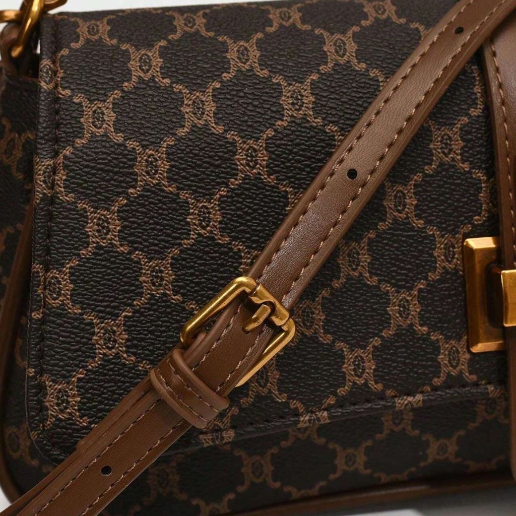 Bolsa baguete Yeda Mayzê. Design retrô em couro ecológico, estampa clássica e alça transversal. O acessório perfeito para looks modernos e sofisticados.