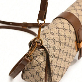 Bolsa baguete Yeda Mayzê. Design retrô em couro ecológico, estampa clássica e alça transversal. O acessório perfeito para looks modernos e sofisticados.