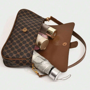 Bolsa baguete Yeda Mayzê. Design retrô em couro ecológico, estampa clássica e alça transversal. O acessório perfeito para looks modernos e sofisticados.