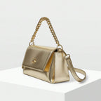 Bolsa pequena Melissa Mayzê dourada. Design tiracolo em couro ecológico, alça de corrente e fechamento magnético. O brilho ideal para festas e eventos especiais.