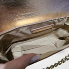 Bolsa pequena Melissa Mayzê dourada. Design tiracolo em couro ecológico, alça de corrente e fechamento magnético. O brilho ideal para festas e eventos especiais.