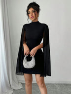 Vestido curto manga capa Nuit Mayzê. Modelagem bodycon, gola alta e capa fluida para um look preto elegante em festas e jantares.