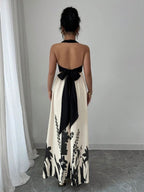 Vestido longo Lien Mayzê com costas abertas e laço. Elegante, fluido e perfeito para casamentos, festas e jantares especiais.